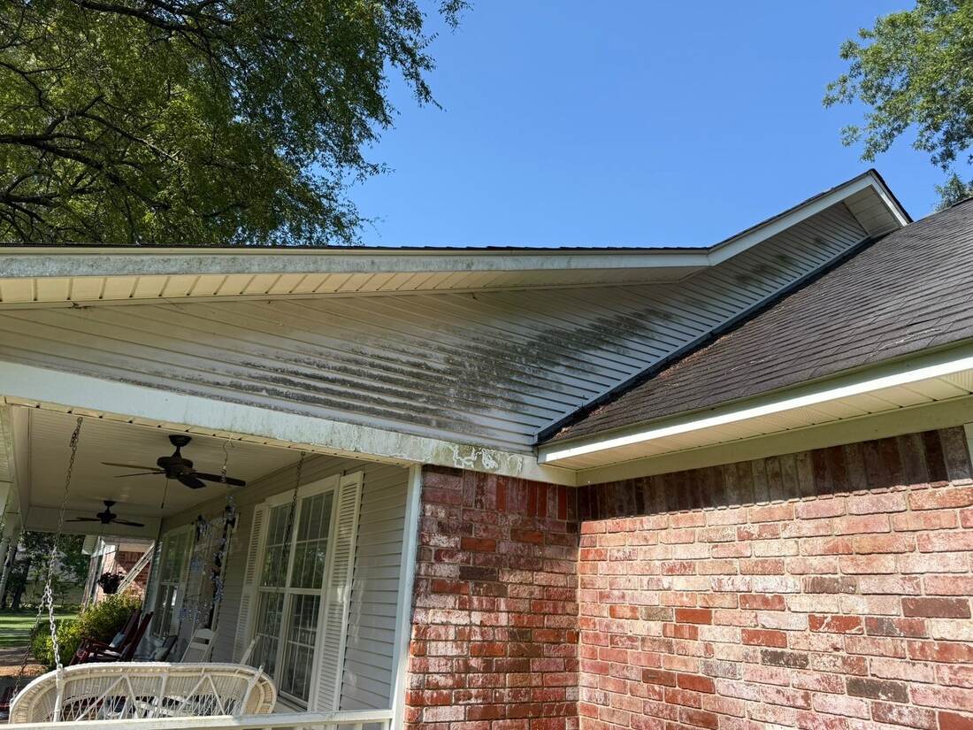 Dirty soffit and brick wall on a house, before cleaning